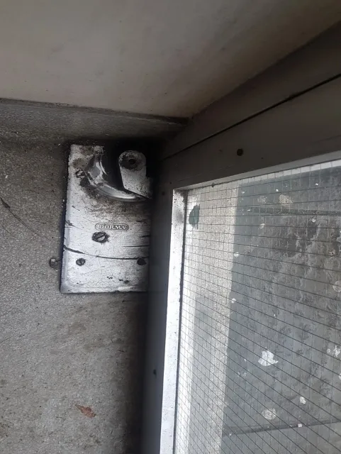 A DORMA floor-level door closer surface-fixed at the base of a wired-glass door