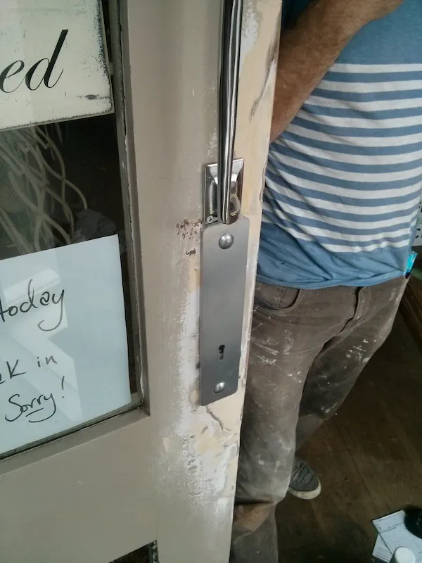 A timber shop front door being repaired on site by CODORE
